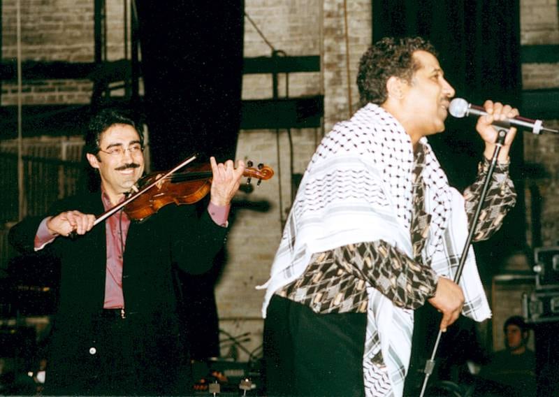 Palestinian-American violinist and oud player Simon Shaheen, left, supporting Khaled at New York's Beacon Theatre in 2002