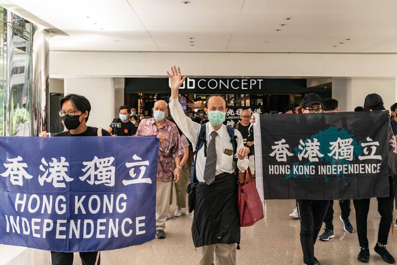 Pro-democracy supporters hold banners and shout slogans as they march in a shopping mall during a lunch protest  in Hong Kong, China. Getty Images