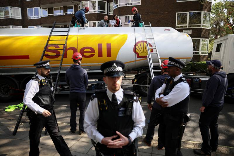 Police officers attempt to remove activists from Extinction Rebellion who occupied an oil tanker during a protest in central London. Reuters