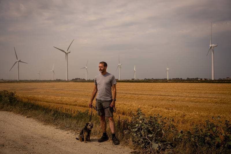 Paul Kershaw walks his dog at the Red Tile Wind Farm near their home in Oakington, Cambridge, UK, on Monday. Bloomberg