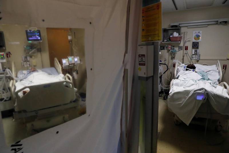 A Covid-19 patient is seen isolated as another patient lies in bed at the intensive care unit of Roseland Community Hospital on the South Side of Chicago, Illinois, USA. Reuters