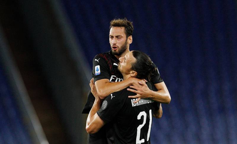 AC Milan's Hakan Calhanoglu, top, celebrates with his teammate Zlatan Ibrahimovic after scoring his side's opening goal at Lazio. AP