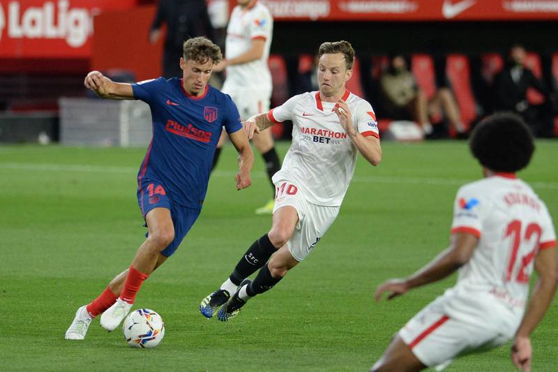 Atletico Madrid's Spanish midfielder Marcos Llorente challenges Sevilla's Croatian midfielder Ivan Rakitic. AFP