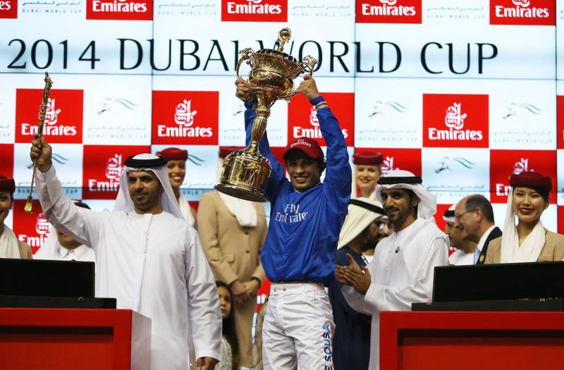 DUBAI , UNITED ARAB EMIRATES Ð Mar 29 , 2014 : Silvestre De Sousa lifts the world cup trophy after wining the Dubai World Cup 9th horse race ( 2000m All Weather ) at the Meydan Racecourse in Dubai. ( Pawan Singh / The National ) For Sports. Story by Jonathan Raymond