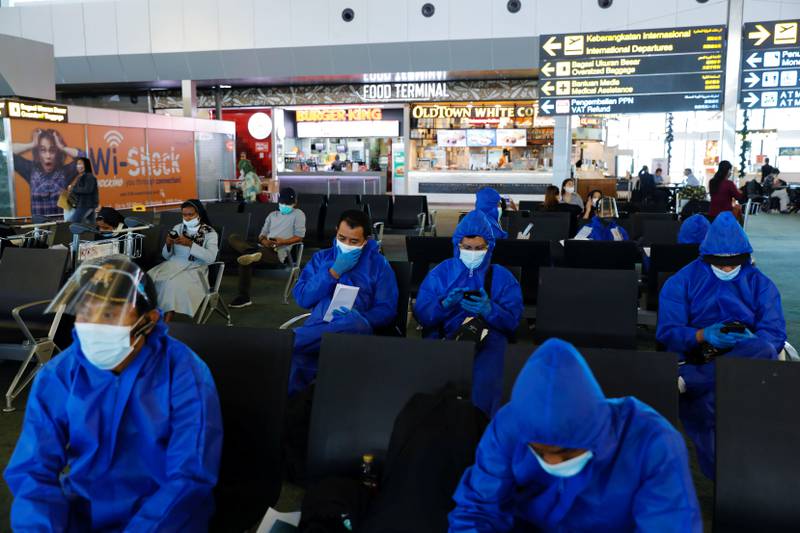 Travellers wear protective suits at Soekarno-Hatta International Airport, near Jakarta. Indonesia has banned travellers from eight African countries in an effort to curb the spread of the Omicron coronavirus variant. Reuters