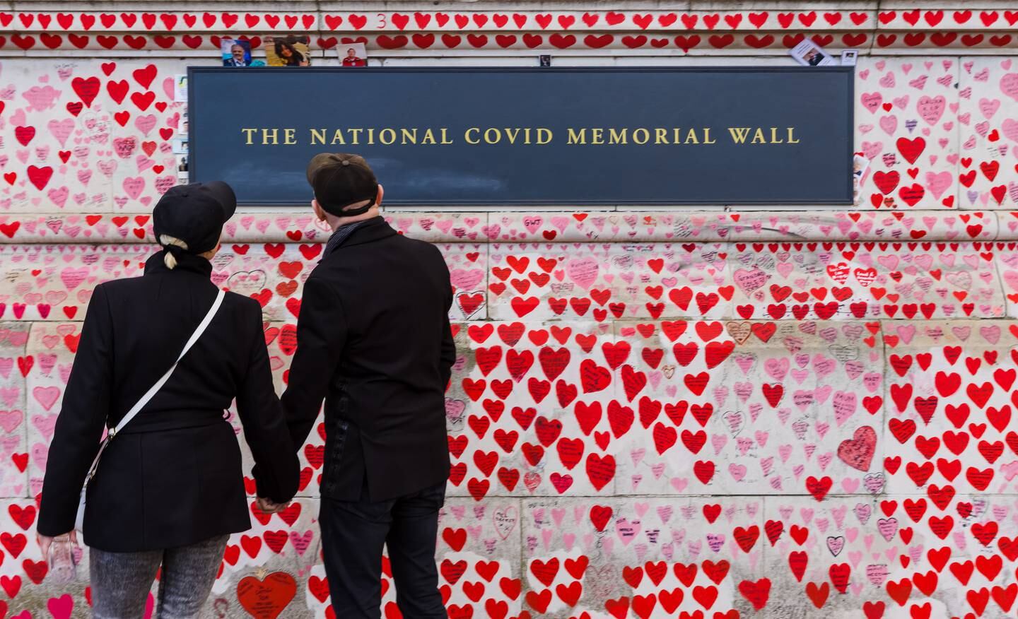 People look at tributes to those who died of Covid-19 in the UK, at the National Covid Memorial Wall in London. EPA 