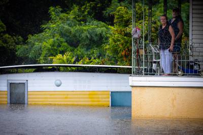 Residents look at floodwaters from the balcony of their home in West Ipswich. AFP