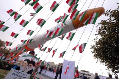 FILE PHOTO: A boy holding a placard with pictures of (L-R) President Hassan Rouhani, the late founder of the Islamic Revolution Ayatollah Ruhollah Khomeini, and Iran's Supreme Leader Ayatollah Ali Khamenei, poses for camera in front of a model of Simorgh satellite-carrier rocket during a ceremony marking the 37th anniversary of the Islamic Revolution, in Tehran February 11, 2016. REUTERS/Raheb Homavandi/TIMA/File Photo/File Photo