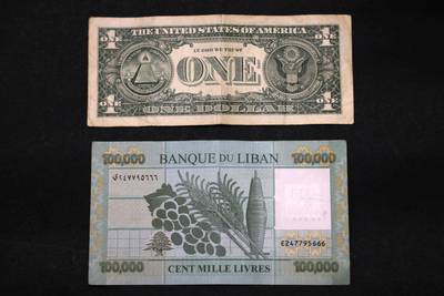 A $1 bill and a 100,000 Lebanese pound note. AFP