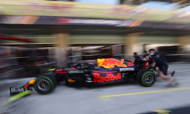 Red Bull mechanics push the car of Max Verstappen ahead of practice. Reuters