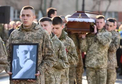 Brothers in arms of serviceman Taras Bobanych, who was killed during the fighting with Russia, carry his portrait and coffin at his funeral in the western Ukrainian city of Lviv. AFP