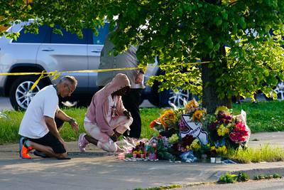 People pay their respects outside the supermarket. AP