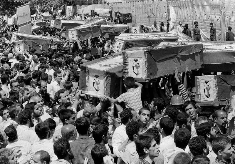 FILE - In this July 7, 1988 file photo, mourners carry coffins through the streets of Tehran, Iran, during a mass funeral for the victims aboard Iran Air Flight 655, which was shot down by the USS Vincennes in the Persian Gulf. The Western allegation that Iran shot down a Ukrainian jetliner and killed 176 people offers a grim echo for the Islamic Republic, which found itself the victim of an accidental shootdown by American forces over 30 years ago. (AP Photo/Canadian Press, File)