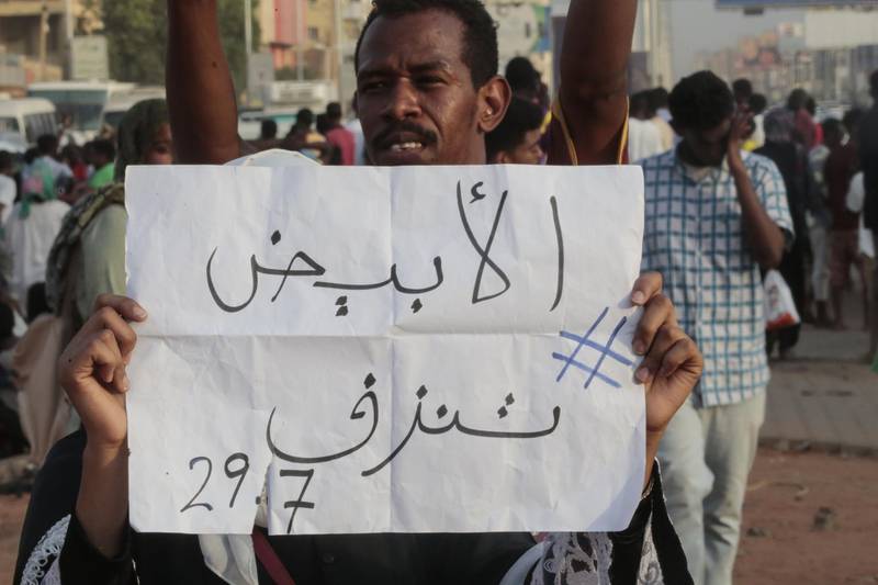 A Sudanese protester holds a placard during a rally in the capital Khartoum to condemn the "massacre" of five demonstrators including four high school students at a rally in a central town of Al-Obeida. AFP