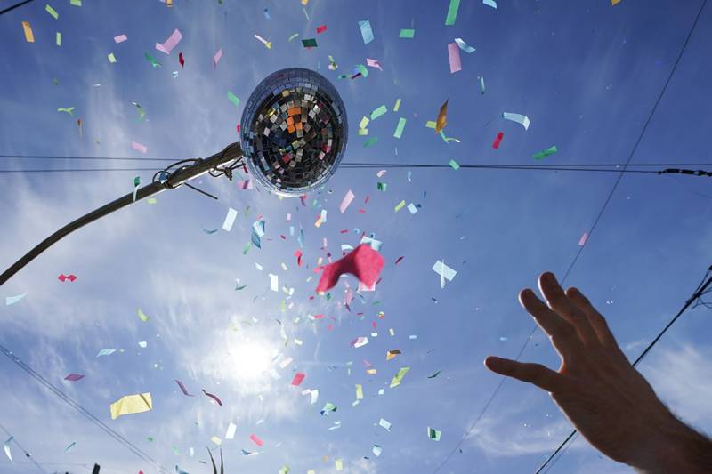 A Societe de Sainte Anne parade visitor throws confetti during Mardi Gras. AP