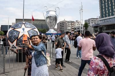 People stand in front of a giant replica of the Champions League trophy in Taksim Square ahead of the Uefa Champions League final in Istanbul. Getty