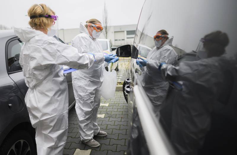 Medics take a swab from a patient outside a doctor's office in Laatzen, Germany. AP