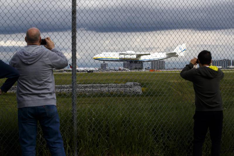People watch as the Antonov AN-225 Mriya aircraft lands. Bloomberg