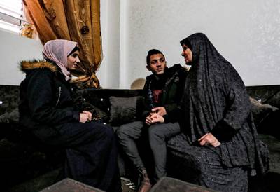 Palestinian groom Ahmed al-Ketnani (C), 27, sits with his 19-year-old fiancee Sara (L) and his mother (R) at his home in Gaza City, after having decided to postpone their nuptials due to the COVID-19 coronavirus disease pandemic.  AFP