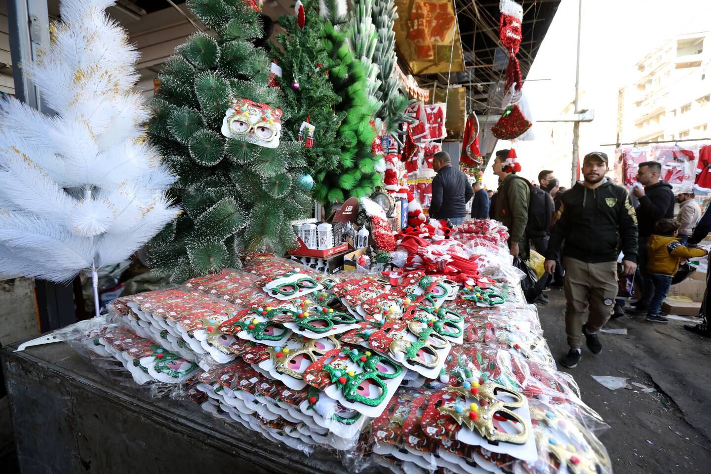 Iraqis walk past Christmas goods being sold at a street shop in Baghdad, Iraq, December 22, 2021. EPA