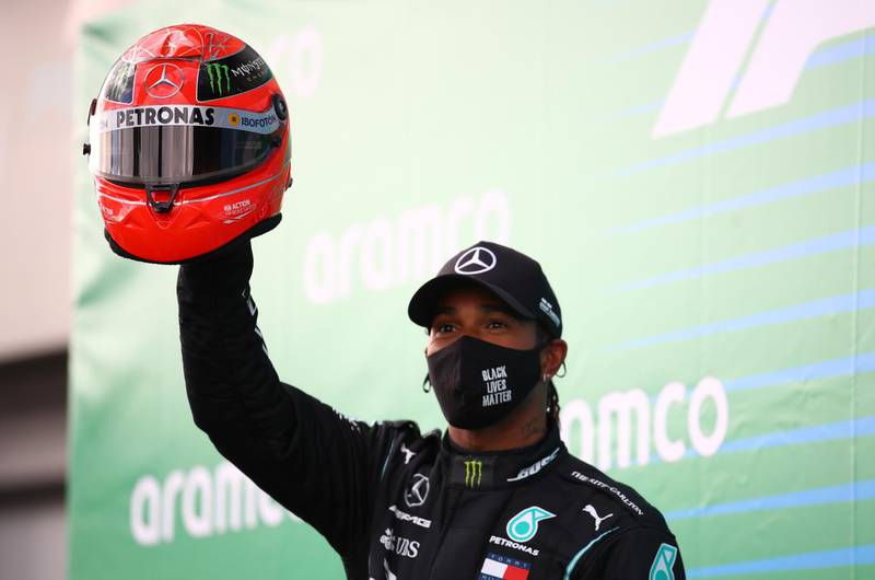 Lewis Hamilton celebrates with the red helmet belonging to Michael Schumacher presented to him by the German's son, Mick,
after winning the Eifel Grand Prix at the Nurburgring, Germany. The victory drew the Briton level with Schumacher Snr's record of 91 F1 race wins. Reuters