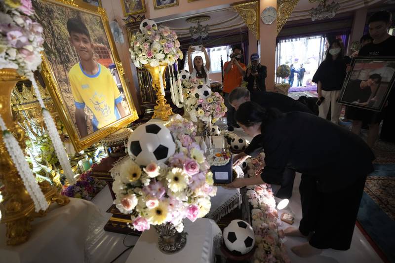 Relatives of Duangphet Phromthep, one of the 12 boys rescued from a flooded Thai cave in 2018, bring his ashes to a temple in the northern Chiang Rai province. He died in the UK this month. AP