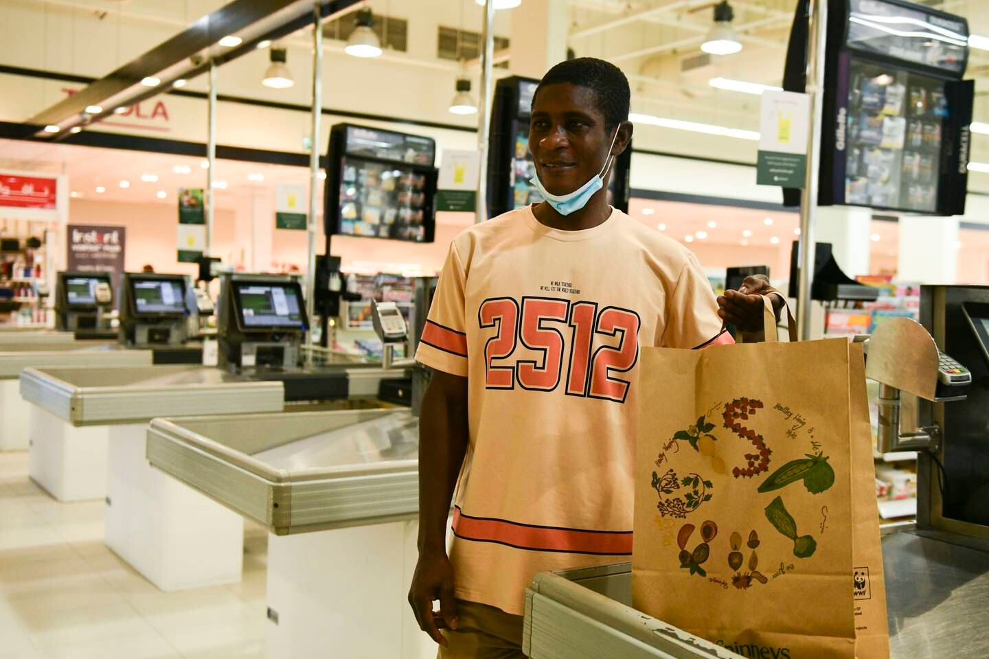 Norbert Sammah, from Ghana buys a paper bag for his groceries at Spinneys Motor City, Dubai. Khushnum Bhandari / The National
