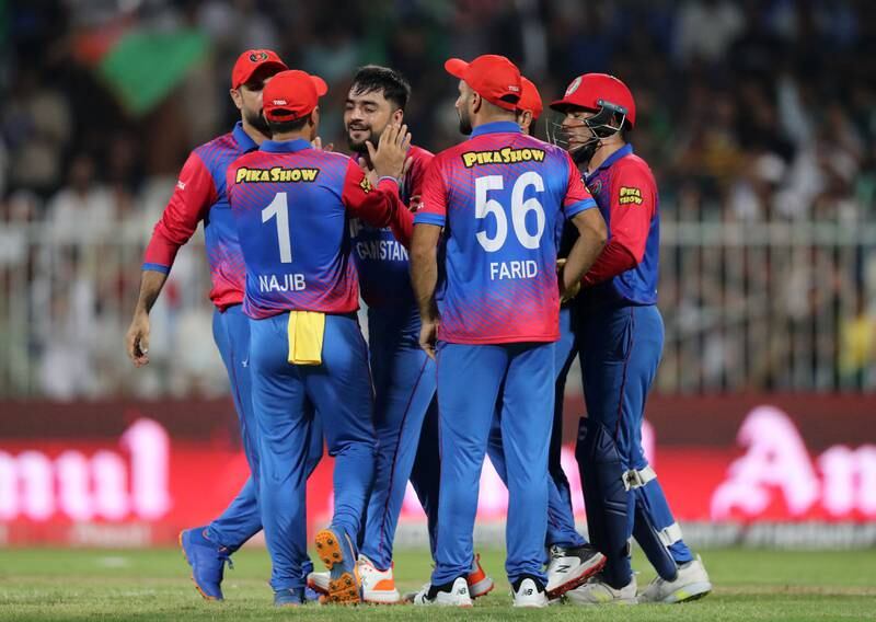 Afghanistan bowler Rashid Khan celebrates with teammate after taking the wicket of Pakistan's Mohammad Rizwan for 20.