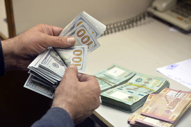 An exchange dealer counts money at a currency exchange office in Lebanon. Two bankers say they have reservations about an IMF-backed government financial recovery plan for the country. Getty Images