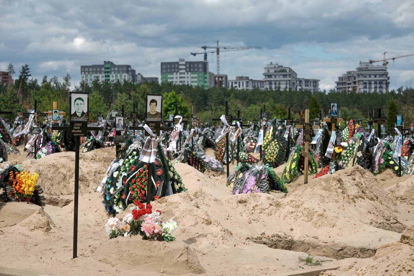 Crosses, flowers and photographs mark the graves of those who died in the battles for Irpin and Bucha, Ukraine. Getty Images