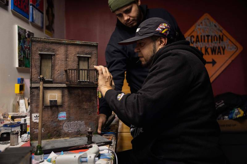 Danny Cortes, a street miniature artist, works on a new miniature at his studio in the Brooklyn borough of New York City on December 19, 2022.  - With his nimble fingers and child-like enthusiasm, Danny Cortes re-creates in miniature the hip-hop-infused street scenes of a gritty New York.  But what began as a hobby has since brought him fame in the rap community and profitable sales even at Sotheby's prestigious auction house.  (Photo by Yuki IWAMURA  /  AFP)