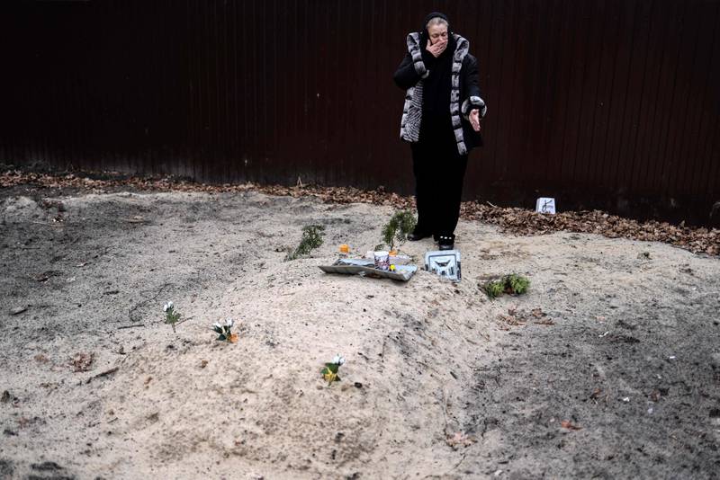 Bucha resident Tetiana Ustymenko weeps over the grave of her son, buried in the garden of her house, in Bucha, north-west of Kyiv. AFP