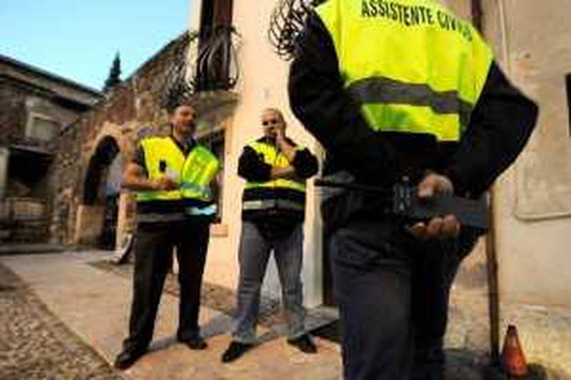 Members of a citizen anti-crime patrol, wearing reflective jackets reading"Civic Assistant", patrol in a street of Verona on October 12, 2009. Italy's recently legalized citizens' patrols which are organized for some 10 years in the north of the country, mainly by members of the far-right Northern League party.   AFP PHOTO / DAMIEN MEYER  TO GO WITH AFP STORY BY MATHIEU GORSE