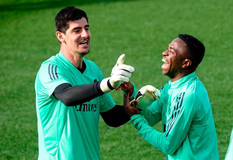 Real Madrid's Belgian goalkeeper Thibaut Courtois jokes with Brazilian forward Vinicius Junior. AFP