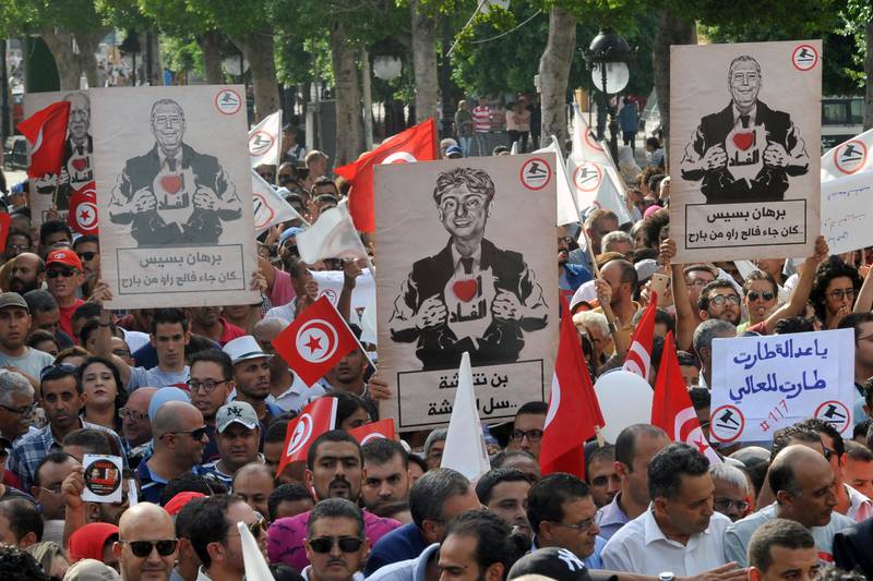 Demonstrators hold placards symbolizing martyrs and reading "I do not forgive" during a march against a contested reconciliation bill which would grant amnesty to officials accused of corruption during the rule of the former regime, on Habib Bourguiba avenue, in Tunis, Tunisia, Saturday, Sept. 16, 2017. Tunisia's Parliament has adopted a hotly disputed law giving amnesty to thousands of people linked to corruption under its pre-revolution authoritarian regime.(AP Photo/Hassene Dridi)