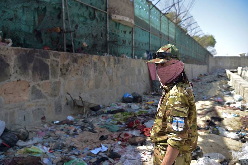 A Taliban fighter stands guard at the site of the explosions, which killed scores of people, at Kabul airport. AFP