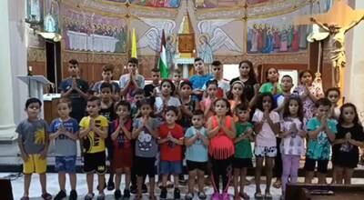 A screenshot from a video posted on Facebook showing children praying at the Holy Family Church in Gaza