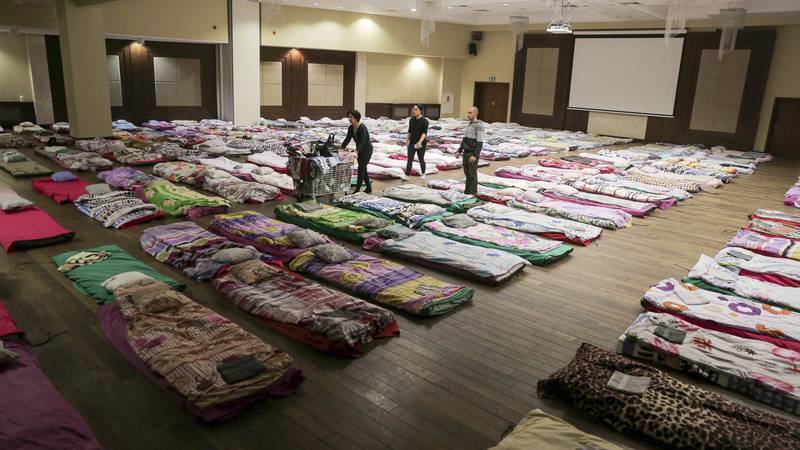 Hospital employees and volunteers make hundreds of beds to prepare for an influx of Ukrainian refugees in Rzeszow, Poland. AP