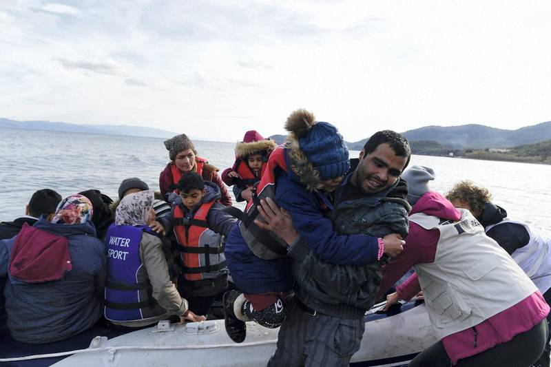 Refugees and migrants arrive with a dinghy at the village of Skala Sikaminias, on the Greek island of Lesbos, after crossing the Aegean sea from Turkey, on Friday, Feb. 28, 2020. An air strike by Syrian government forces killed scores of Turkish soldiers in northeast Syria, a Turkish official said Friday, marking the largest death toll for Turkey in a single day since it first intervened in Syria in 2016. (AP Photo/Micheal Varaklas)