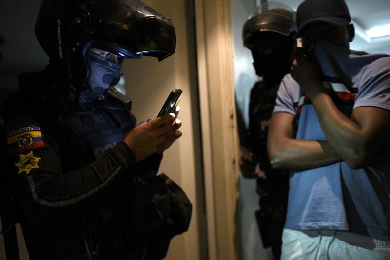 An officer checks a man's phone during a police operation to tackle those breaking Covid-19 restrictions in Guayaquil, Ecuador. Reuters
