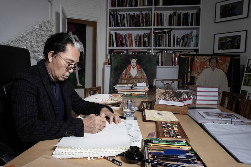 Japanese fashion designer Kenzo Takada drawing during a photo session in his home in Paris on January 9, 2019. AFP