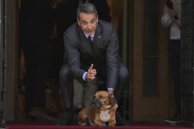 Greece's Prime Minister Kyriakos Mitsotakis pets his dog Peanut before the arrival of Finland's Prime Minister Sanna Marin at Maximos Mansion in Athens, Greece. AP