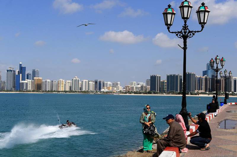 People enjoying a sunny day and warm weather watching jet skiers near flag point on Corniche in Abu Dhabi as skies clear up after the previous day's non-stop rain. Ravindranath K / The National


