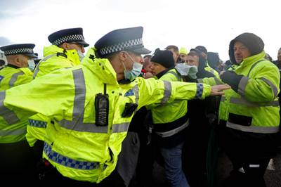 Police officers scuffle with drivers trying to stop trucks leaving the port and keep it closed until they are allowed to travel to Europe, at the Port of Dover, as EU countries impose a travel ban from the UK following the coronavirus disease (COVID-19) outbreak, in Dover, Britain, December 23, 2020. REUTERS/John Sibley