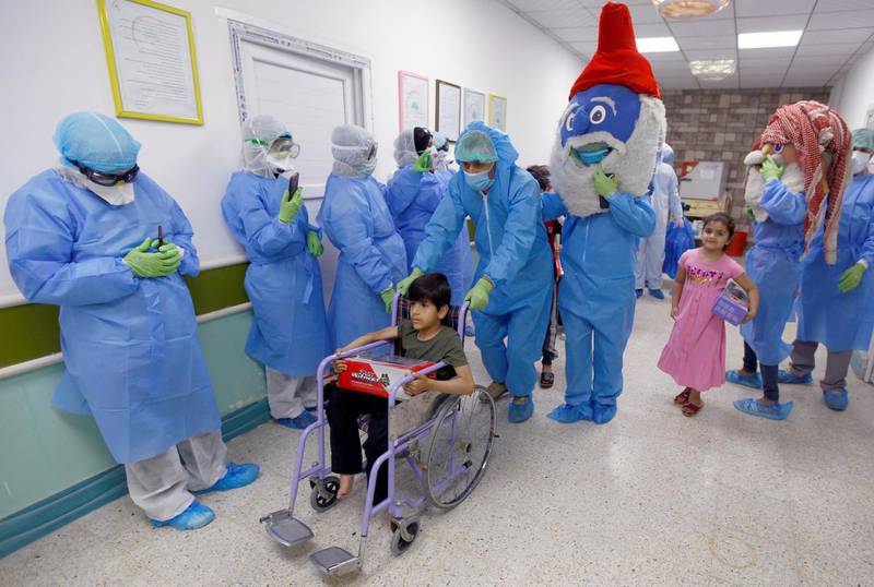 Nurses and volunteers wearing protective suits and face masks are seen, as puppets perform to entertain children who were infected with the coronavirus disease (COVID-19) and have recovered in a quarantine ward, at a hospital in the holy city of Najaf, Iraq.  REUTERS