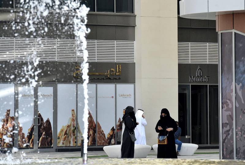 A picture taken on October 22, 2018 shows Saudis walk in front of a mall in the capital of Riyadh. (Photo by FAYEZ NURELDINE / AFP)