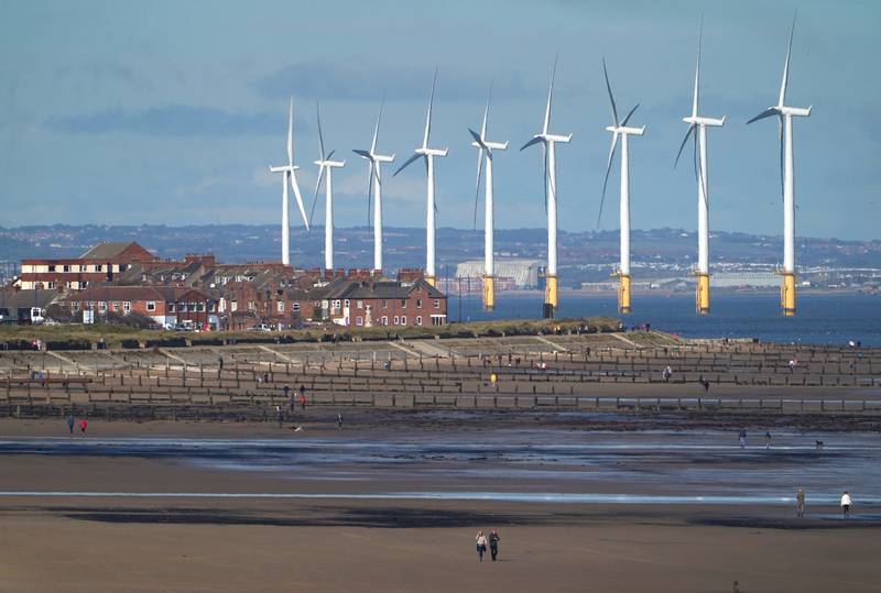 A wind farm in north-east England. Britain's transition from a high-polluting to a low-carbon producing economy must be accelerated, an industry panel has heard. PA