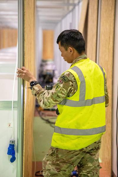 A member of the Queen's Ghurka Engineers Regiment helps to build the new NHS Nightingale Hospital. Courtesy Reuters