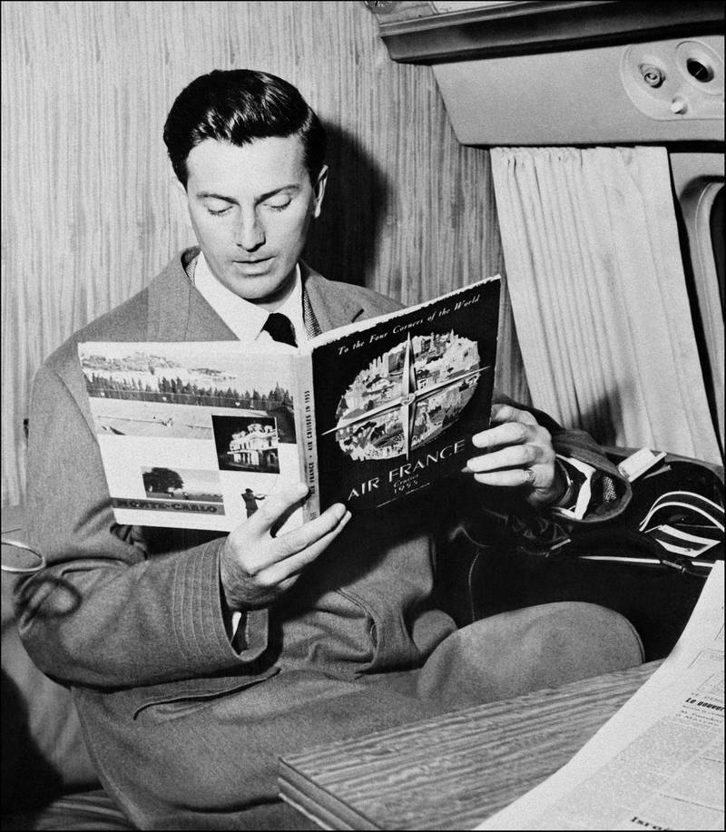 In this photo taken on July 04, 1957 French fashion designer Hubert de Givenchy reads a magazine aboard a flight in Beauvais. AFP