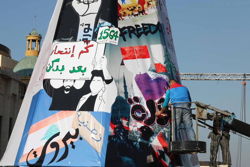 Lebanese anti-government protesters erect a Christmas tree made of protest banners in Beirut's Martyr Square. AFP